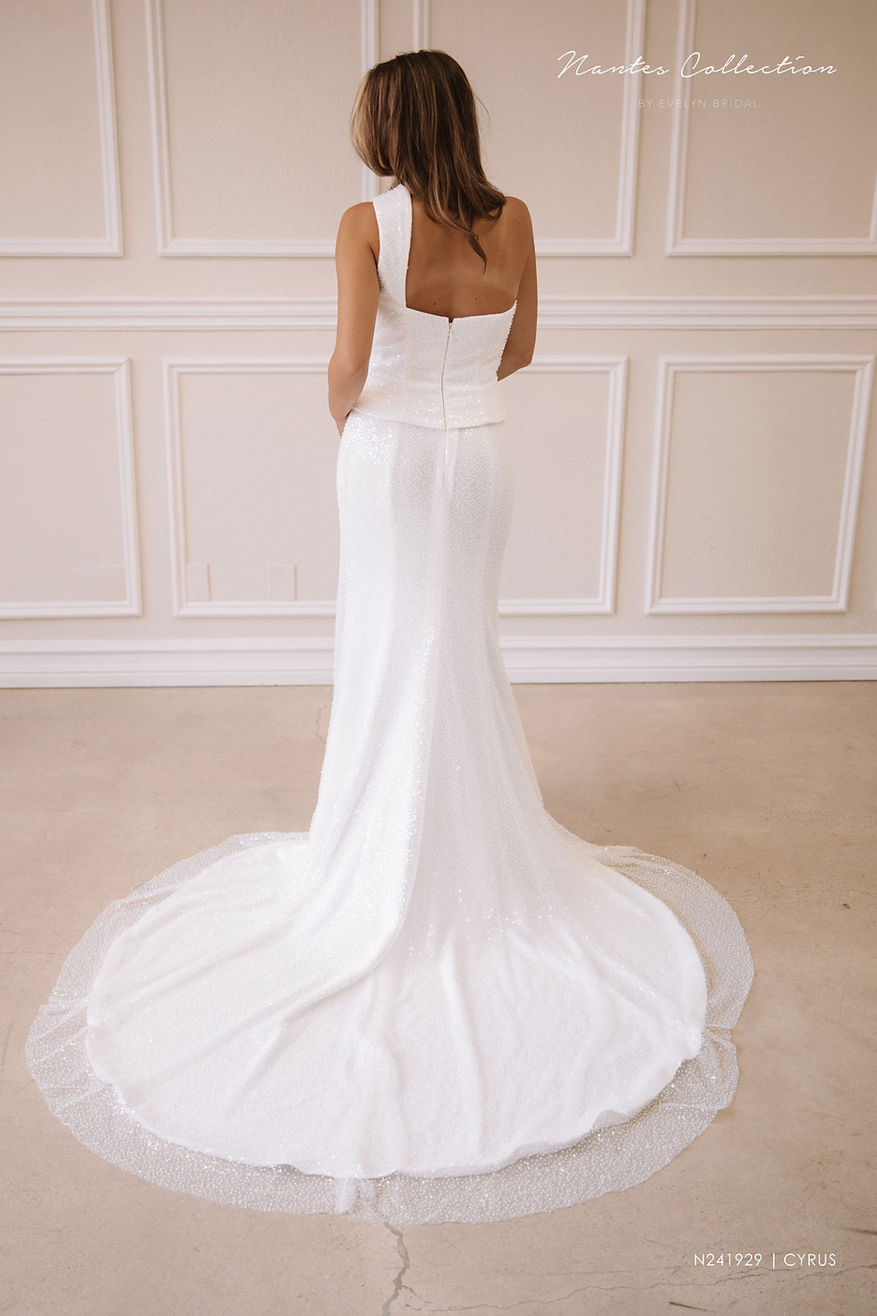 Thumbnail: Cyrus | N241929
Gown Info
Step into timeless elegance with this chic gown featuring a flat neckline. This dress boasts a single shoulder design, creating the illusion of a two-piece ensemble. The fishtail skirt showcases a second layer in crepe, while the first layer is adorned with stunning crystal stone Organza lace. The upper body is delicately pleated with crystal stone sequin-accented Organza lace, adding a touch of luxury and texture to the look.

Material
Crepe/Lace

Color & Size
Shown in Ivory/Ivory

Available Sizes: 2 - 28 / 14W - 32W Size Chart