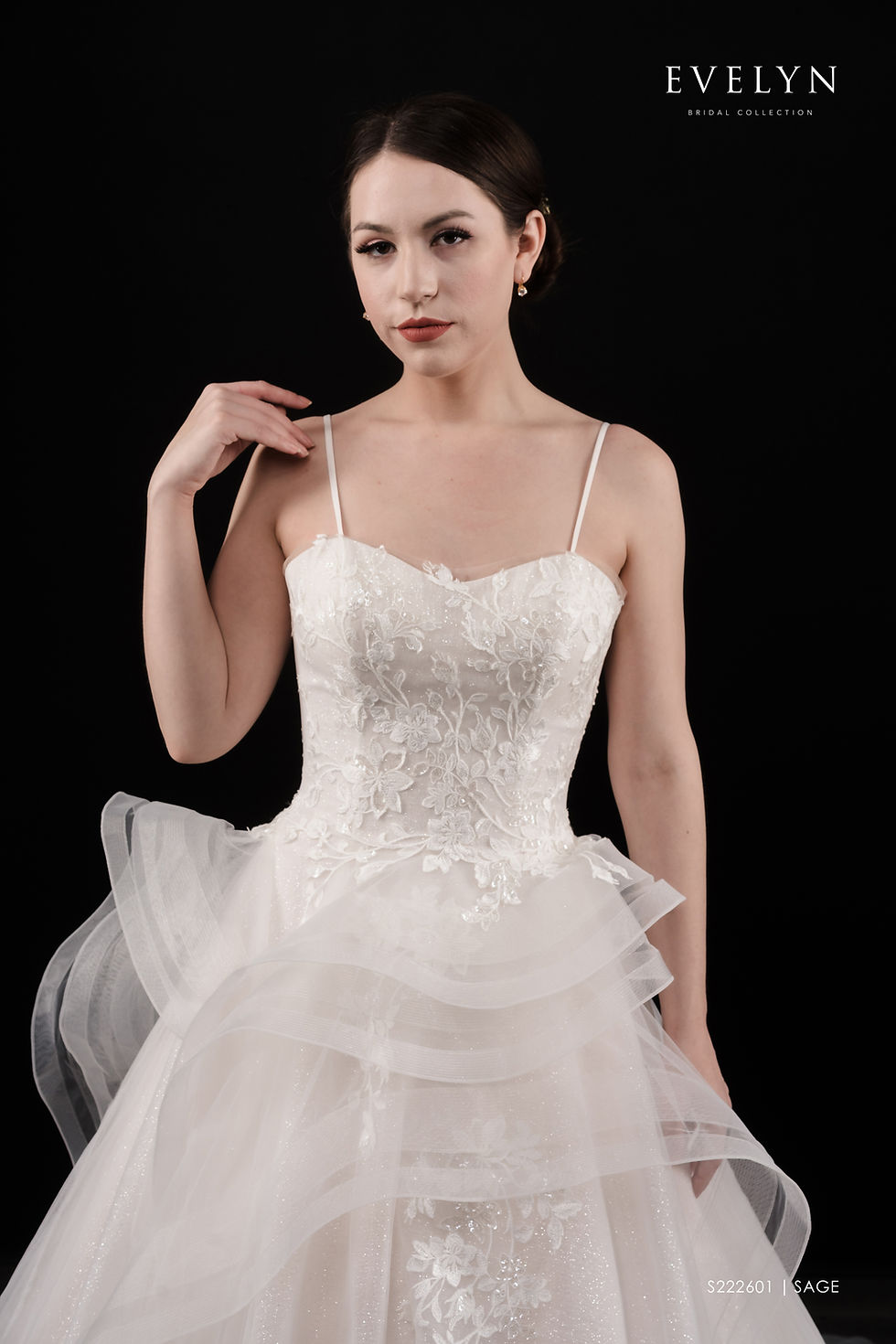 Thumbnail: SAGE | S222601
Gown Info
Straight of a fairytale for your wedding day! This tulle gown features floral lace appliques and delicate thin straps on the bodice. The tulle ballgown skirt features the same romantic lace as the bodice and tiered ruffled tulle that creates a unique textured look. The skirt flows into a chapel length train completing the dramatic look!

Material
Lace Tulle

Color & Size
Ivory/Champange (Shown)

Ivory/Ivory

 

Sizes available 2-28  / 14W-32W