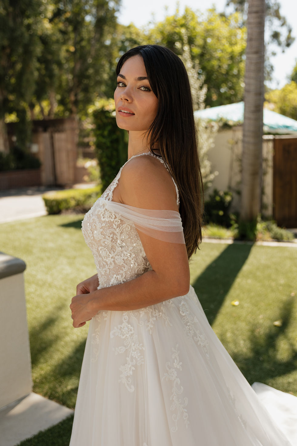Thumbnail: Tori | N25525
Gown Info
Embrace the epitome of allure and romance in this enchanting gown, meticulously crafted to captivate hearts. The upper body features intricate layers of applique tulle. The lower skirt cascades in layers of airy tulle gracefully paired with two layers of silky lining, ensuring a luxurious feel against the skin. Perfect for intimate evenings or grand celebrations, this gown embodies sensuality and invites you to exude confidence and elegance with every step.

Material
Tulle/Lace

Color & Size
Shown in Ivory/Pearl

Also available in Ivory/Ivory

Available Sizes: 2 - 28 / 14W - 32W Size Chart
