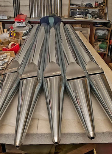 Five polished metal organ pipes
