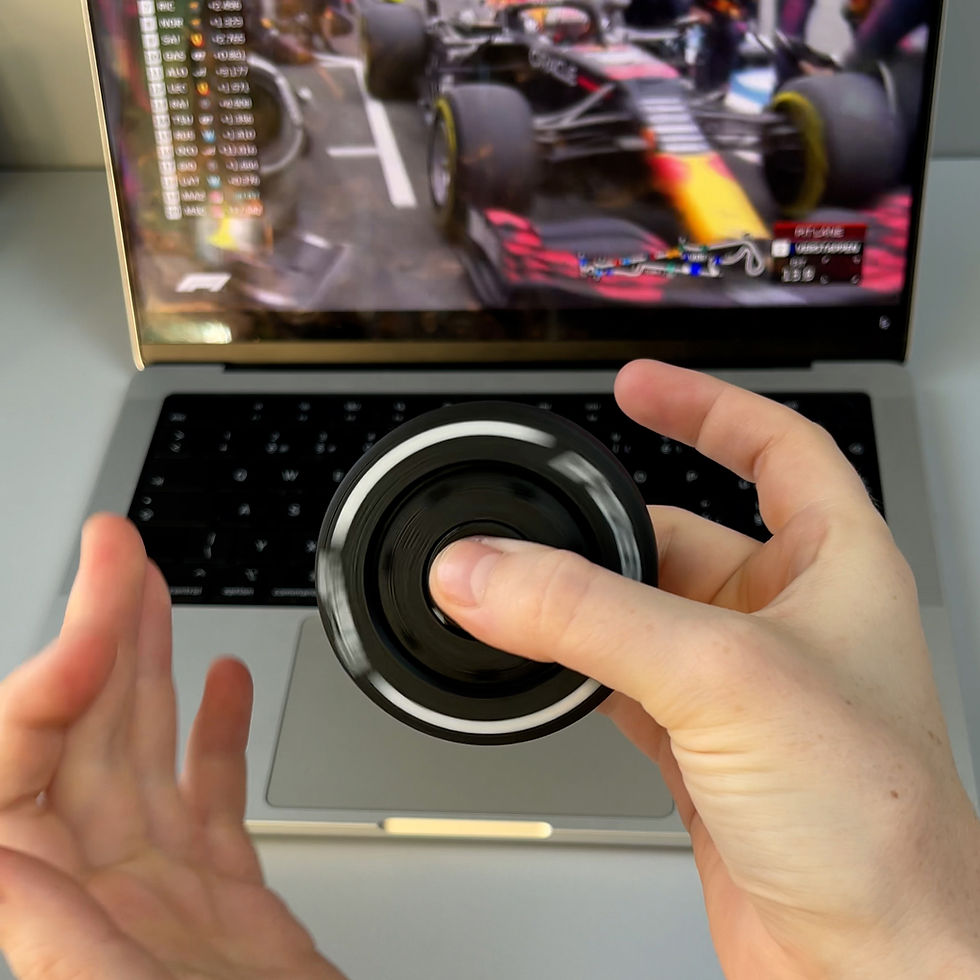 Прев'ю: Фіджет у формі шини Pirelli Hard обертається в руках на фоні трансляції Формули 1