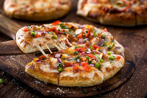 Close up image of a personal sized veggie pizza with a cheesy slice being pulled out. Dallas Food Photographer