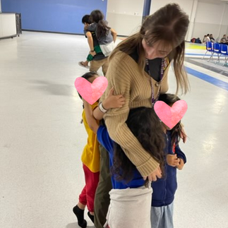 volunteer receiving hugs from children