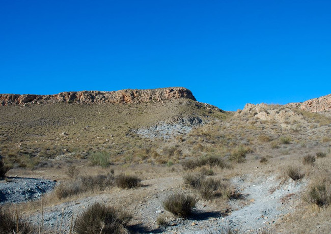 Los granates o “granate almandino”, se localizan por todo el “cono” volcánico. Esta piedra preciosa se caracteriza por su dureza, solo tres puntos por debajo del diamante y llegaron a la superficie arrastrados por la lava volcánica. Una vez el suelo y las rocas volcánicas se han ido erosionando por las lluvias torrenciales de la zona, han ido apareciendo en la superficie los granates distinguiéndose a simple vista