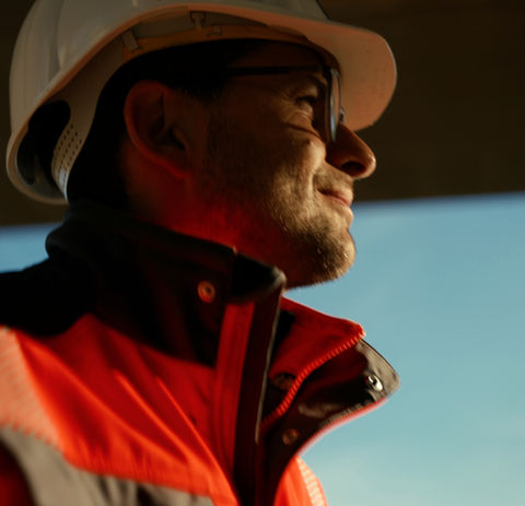 Mineur im Tunnelbau mit Schutzhelm und Warnkleidung. Szene aus dem Imagefilm „Tunnel. Schaffen. Zukunft.“ für den Hauptverband der Deutschen Bauindustrie.