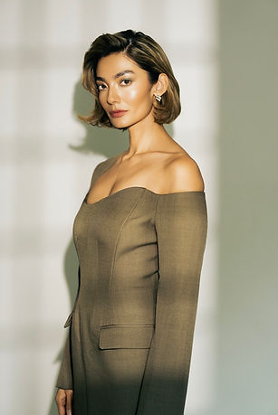 Woman with short brown hair in an off-the-shoulder dress
