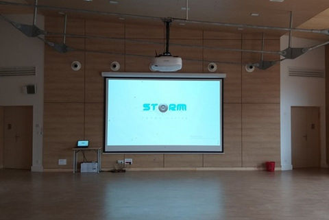 Projecteur affiche le logo STORM sur un écran dans une salle de conférence STORM SONO