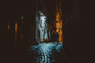 "Deserted southern street at night with flickering street lamps and shadowy buildings, evoking urban haunted settings in the Southeast"