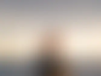 Voilier à trois mâts avec voiles blanches "Ponant", navigue au coucher du soleil sur l'océan calme, ciel doré en arrière-plan.