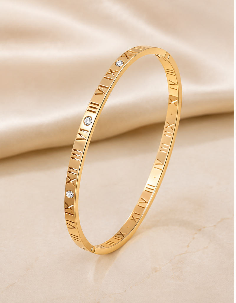 18K Gold Plated Oval Roman Numeral Bangle standing on stone