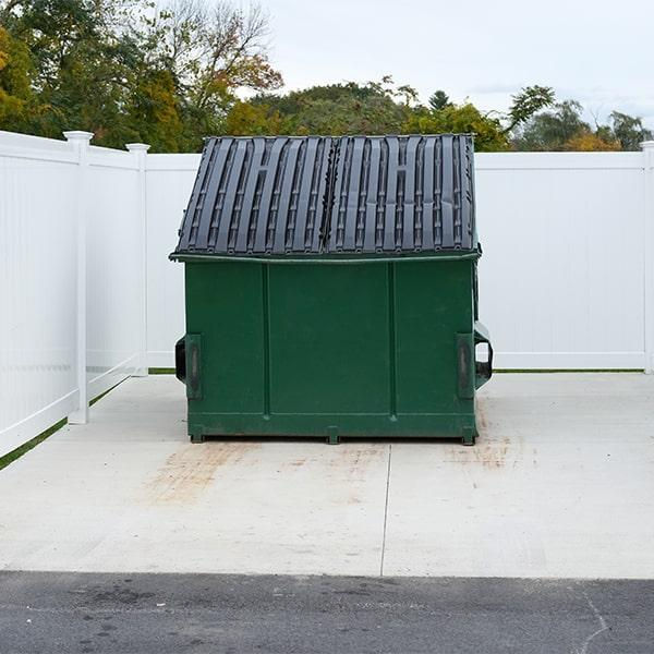 Green dumpster on concrete