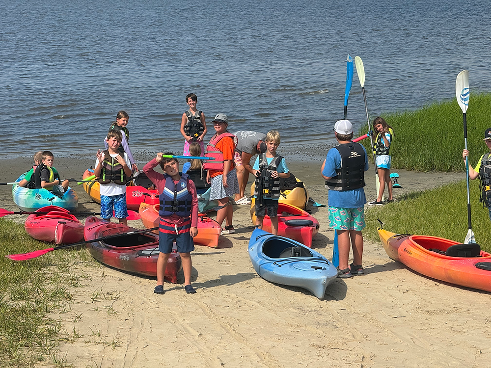 Children and instructor preparing kayaks at Coastal Adventures Camps.
