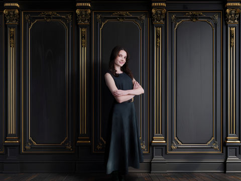 Woman posing confidently in a studio portrait against a black and gold ornate backdrop photographed in Lawrenceville, Georgia.