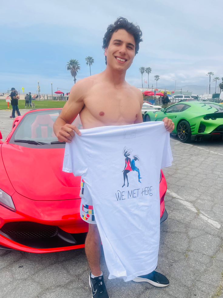 Man showing graphic white tee outdoors