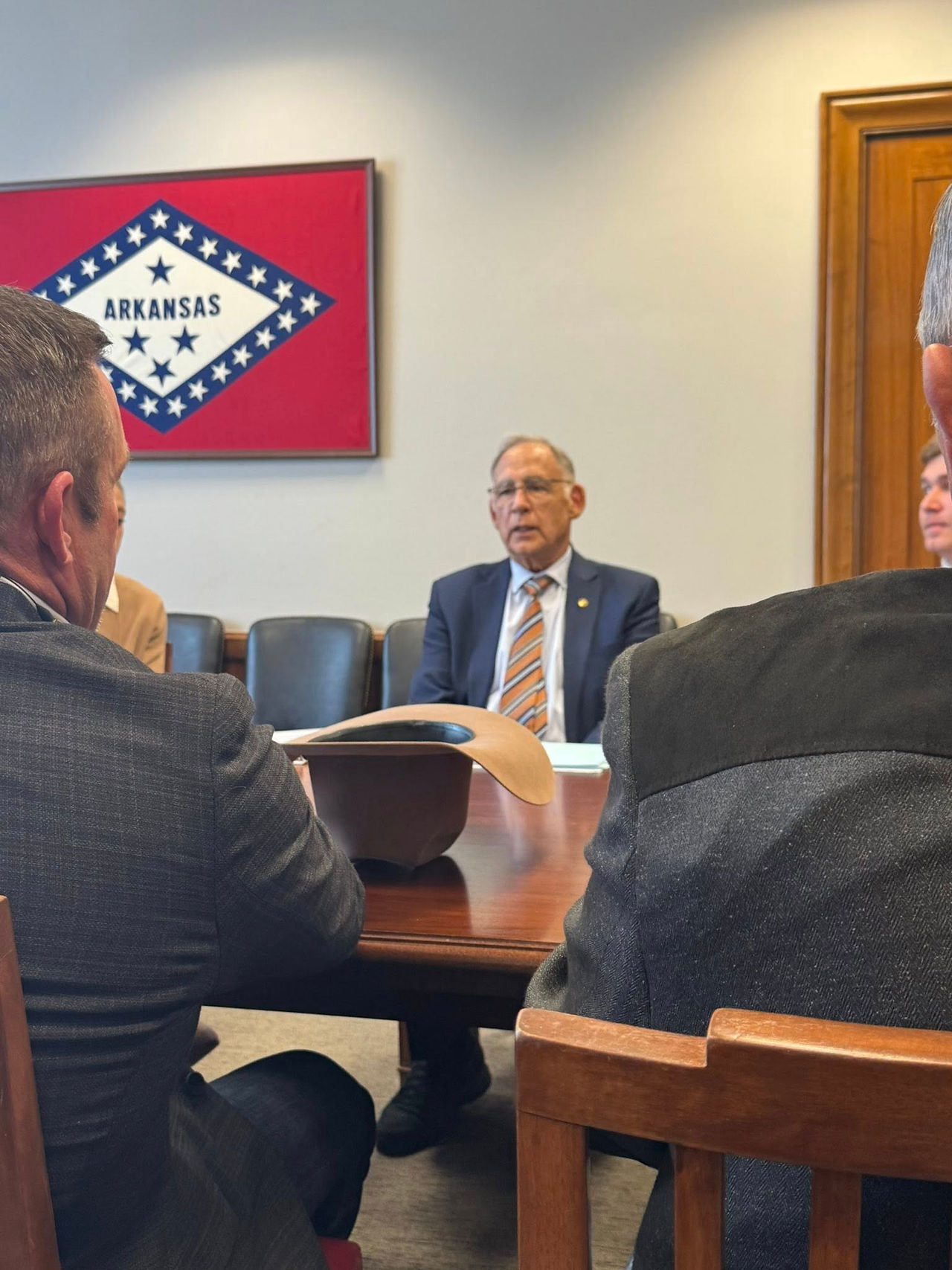 A cowboy hat in the foreground with Senator Boozman in the background.