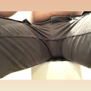 Packing with Mister Limpy M, front view in cargo shorts while sitting with legs spread