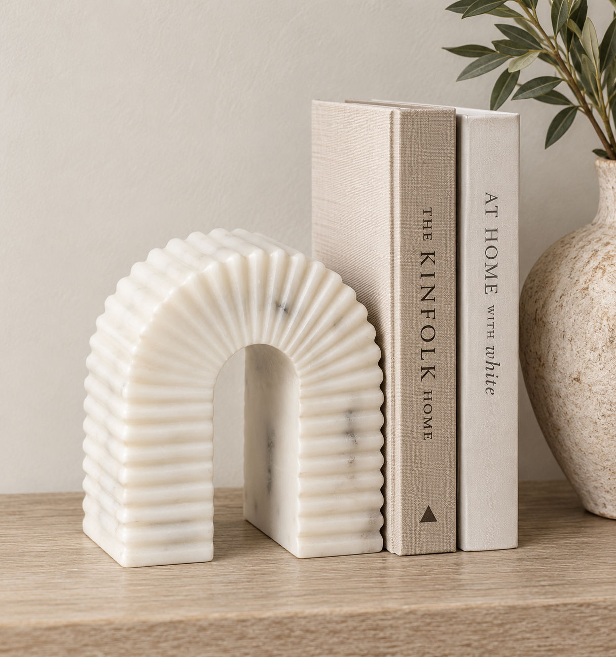 Fluted arch white marble bookend holding up books on a shelf