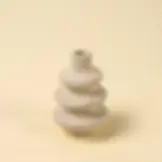 Gray ceramic vase with layered design, set against yellow background.