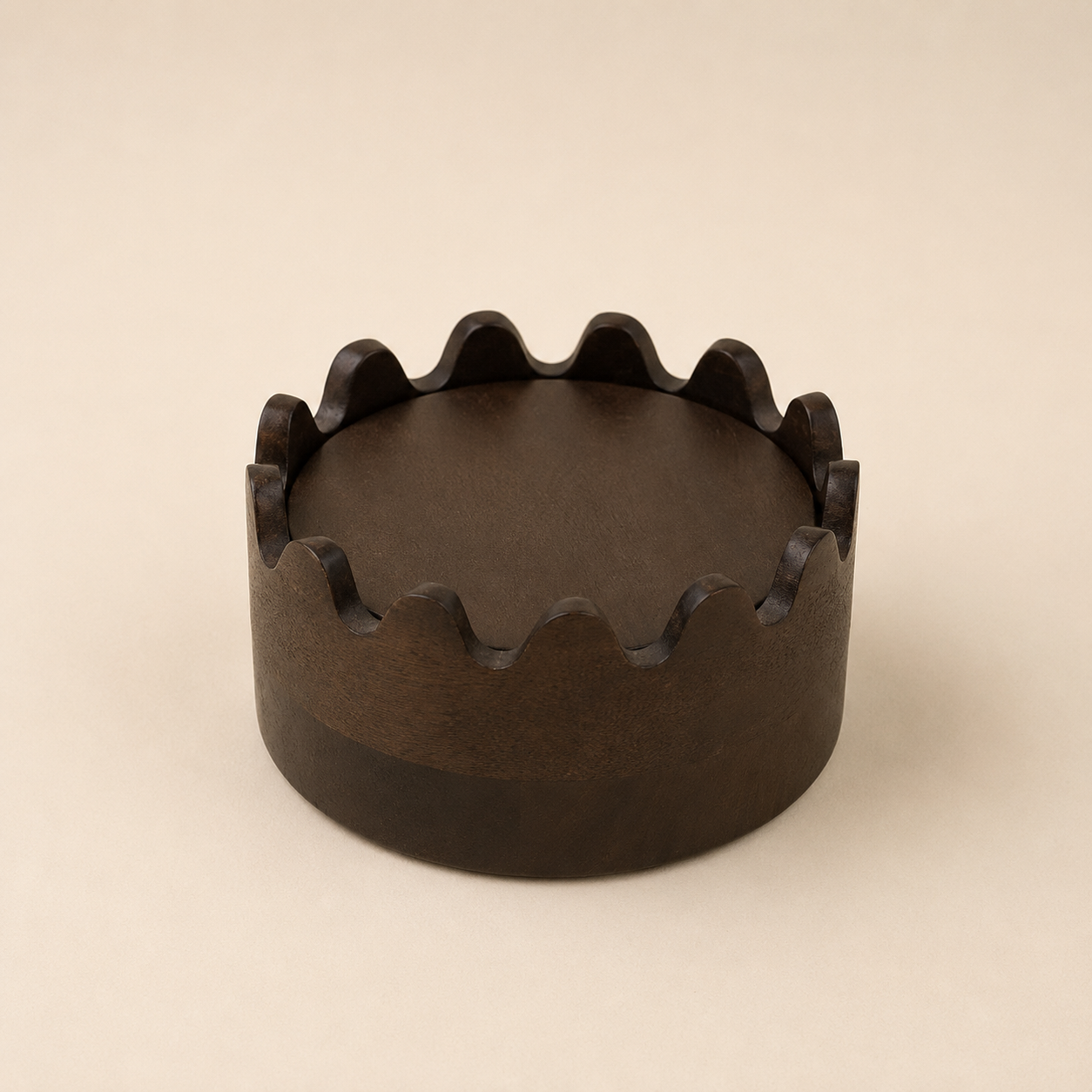 Stack of dark brown wooden coasters in a scalloped holder