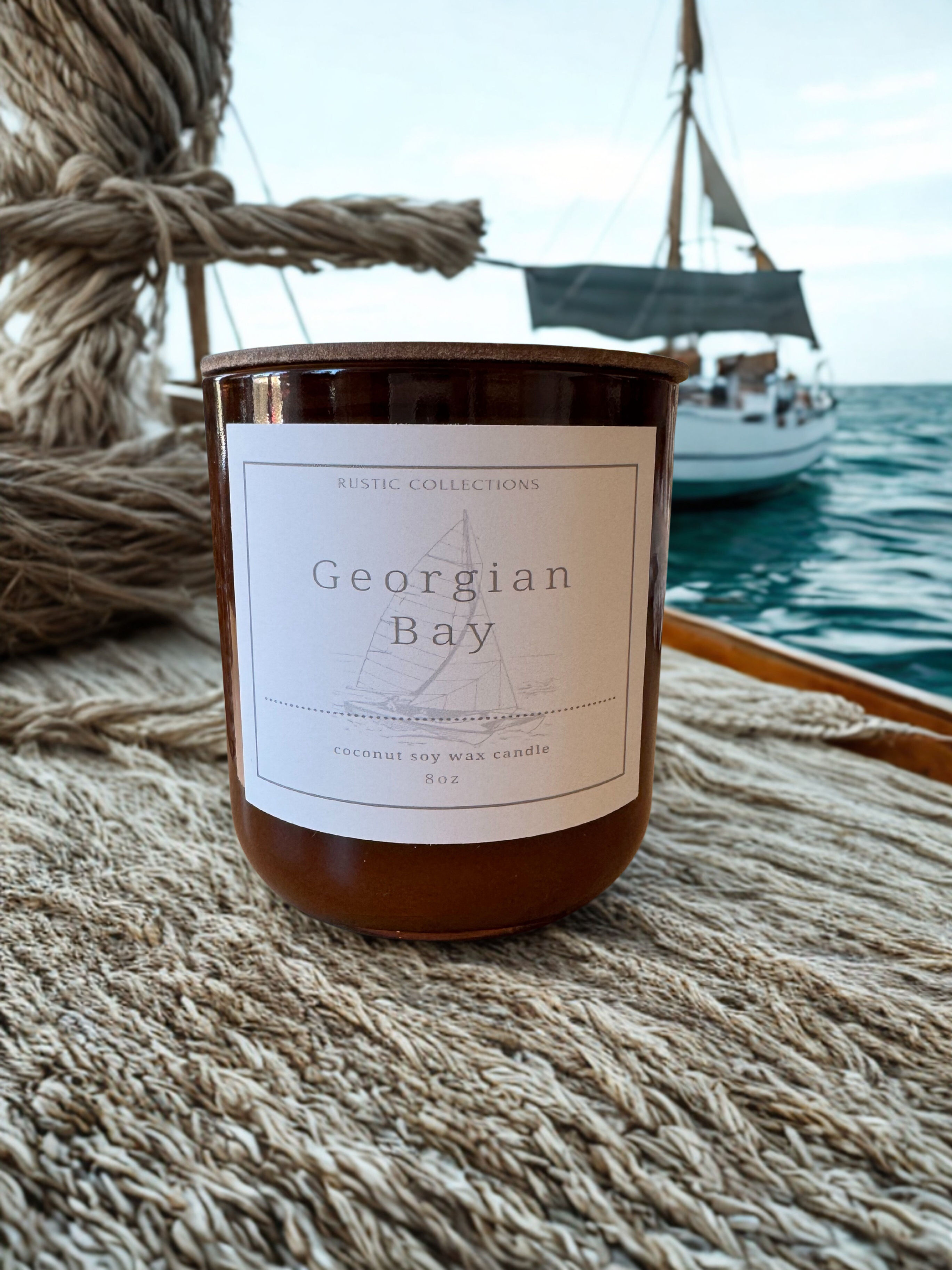 Georgian Bay candle 8oz sits on a boat with sailing in the background.