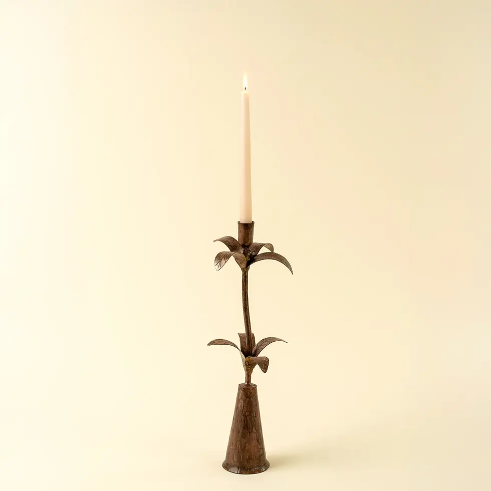 A tall, elegant candlestick with a lit candle, on a beige background.