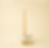 Tall beige candle lit in a ceramic holder