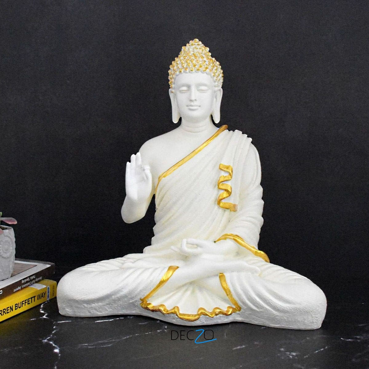 White Buddha statue with gold accents, seated in lotus position, Ringal Artisans Haven.