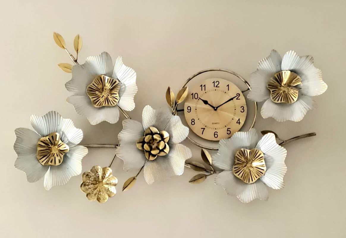 Floral clock arrangement with white flowers and gold accents on a wall.