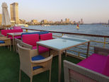 Guests enjoying coffee at an outdoor marine lounge on a floating hotel deck in Cairo