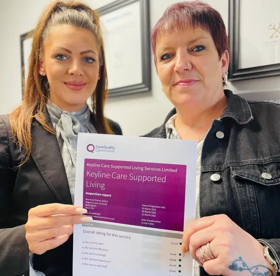 Two Keyline Care support workers pose with CQC certificate.
