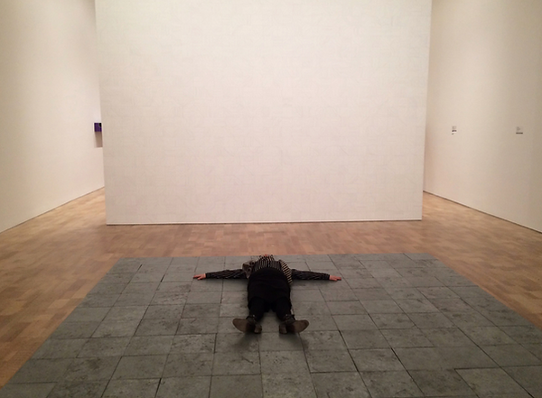 The writer lying on Carl Andre’s “144 Pieces of Zinc” (1967)