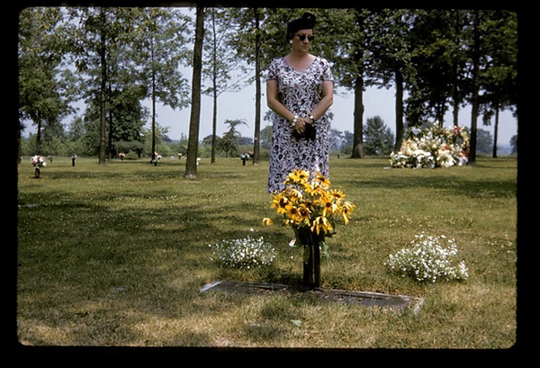 Woman at a cemetary with fresh flowers