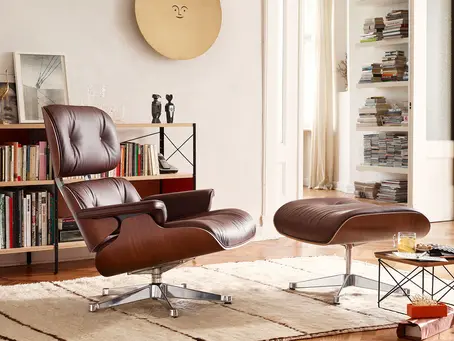 A Mid-century modern Eames chair in a living room with book shelf.
