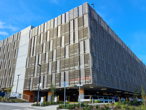 Campbelltown Hospital multi-storey carpark facade, Modern building with patterned metal facade, blue sky overhead.