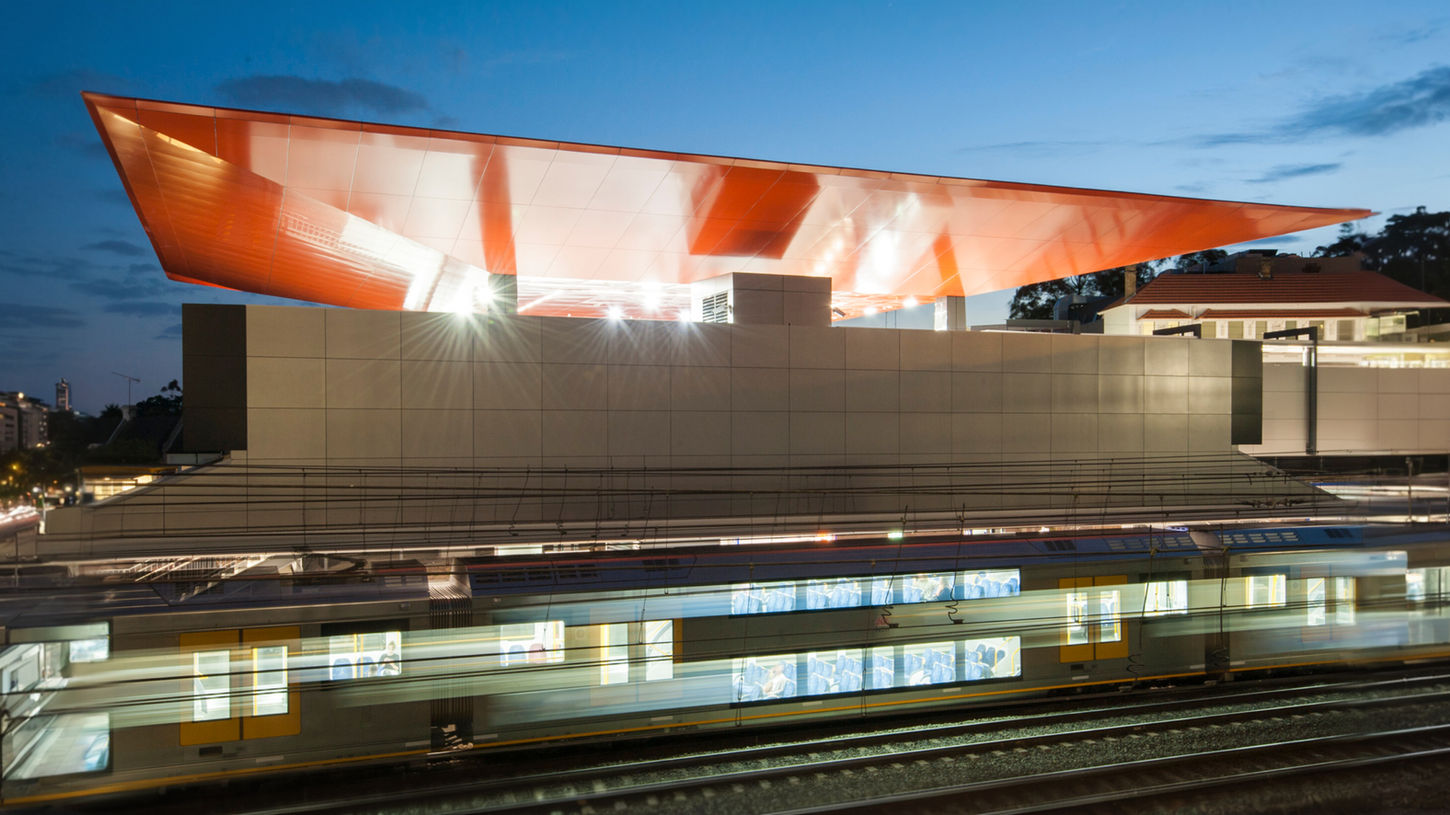 Newtown Railway Station - Contemporary railway station structure illuminated at night beside railway tracks