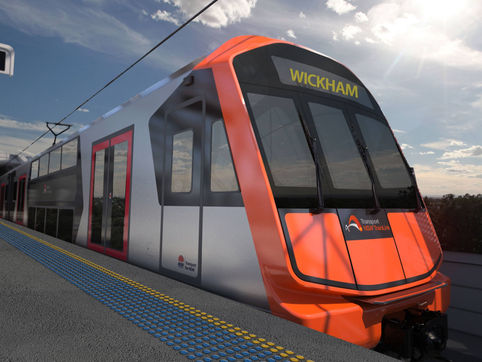 Futuristic orange-and-gray train at Wickham station with people on the platform under a bright sunny sky; TrainLink logo visible.
