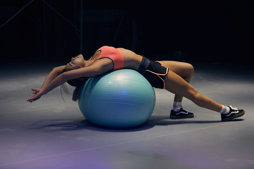 Woman stretching her back over a blue exercise ball