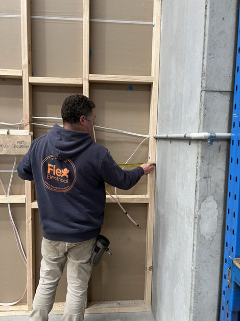 Worker measuring wooden stud wall