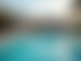 Luxury poolside scene at sunset, modern house with open patio. White loungers line pool, greenery on pergola, calm and inviting mood. Mornington Web Design