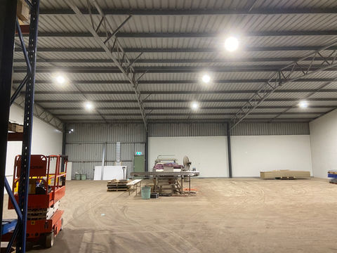 Spacious warehouse interior with bright lights and equipment