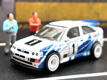 A Ford Escort Cosworth rally car in a garage