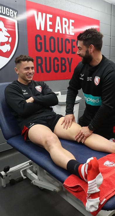 Cheltneham-based-physio-assesing-knee-injury-of-gloucester-rugby-player