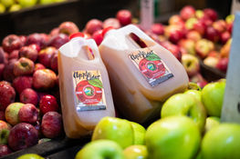Fresh apple cider displayed on an apple crate at Avila Valley Barn.
