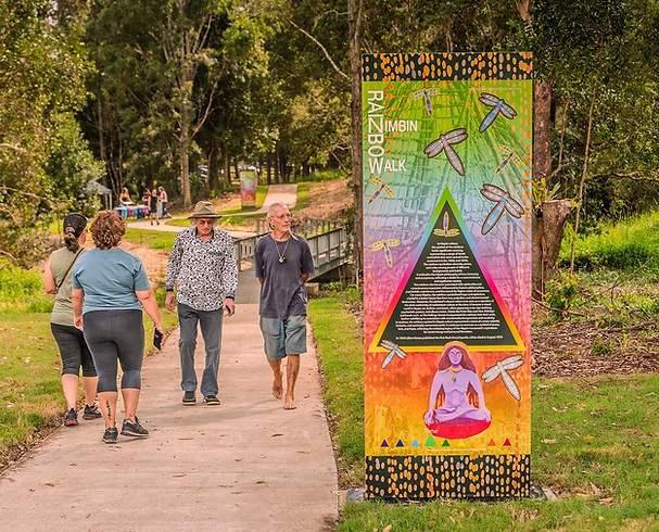Rainbow Walk sign, people stroll on path