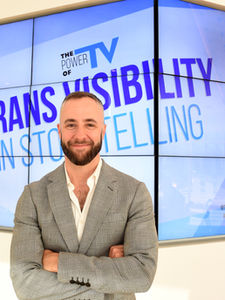 David Ambroz standing in front of monitors promoting Trans Visibility in Storytelling