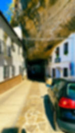 Picturesque view of Setenil de las Bodegas, with traditional white houses built directly into dramatic, overhanging cliffs, creating a unique blend of nature and architecture.