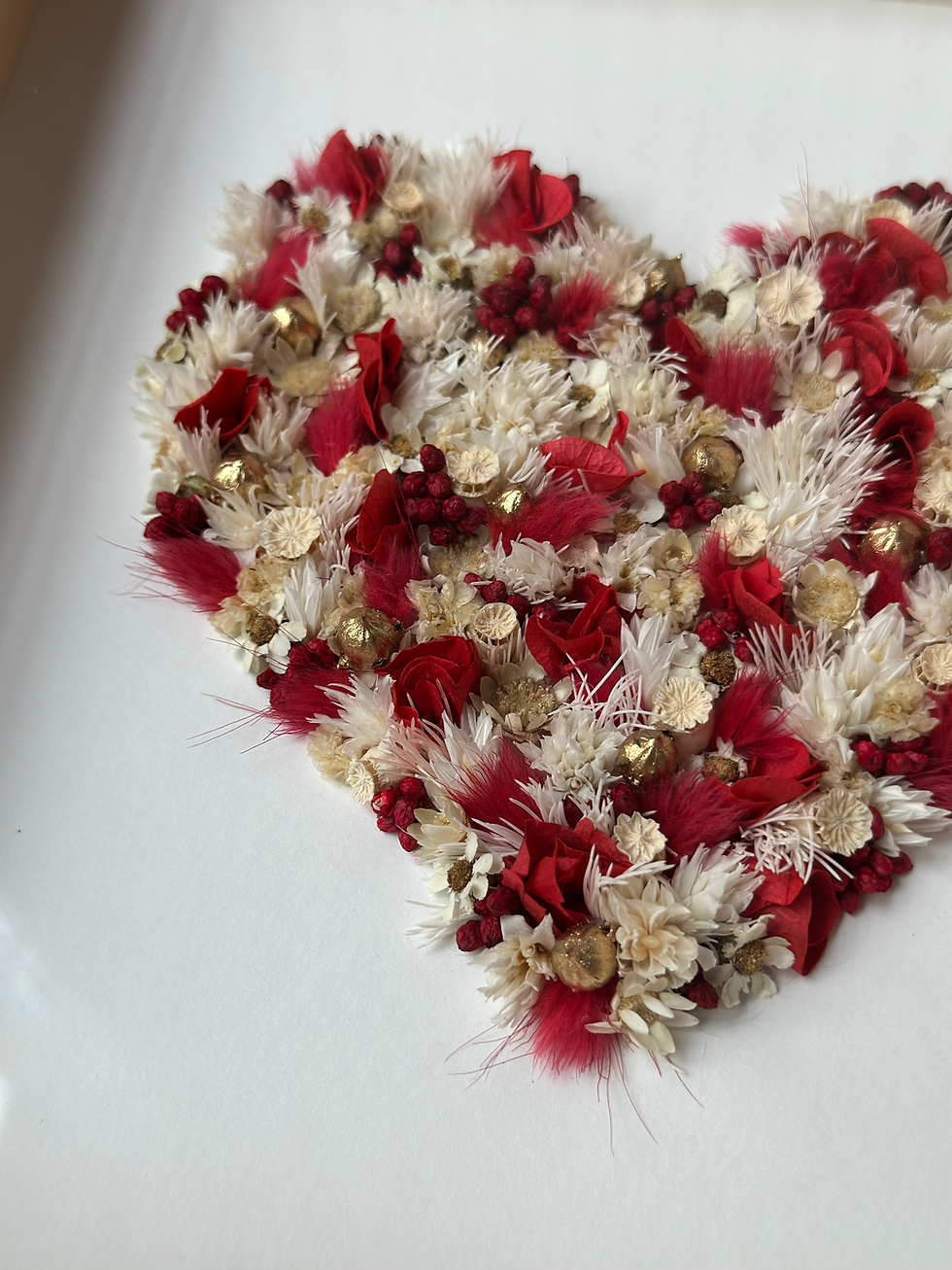 cadre en bois non verni avec un coeur en fleurs séchée, rouge, blanc et doré, décoration murale