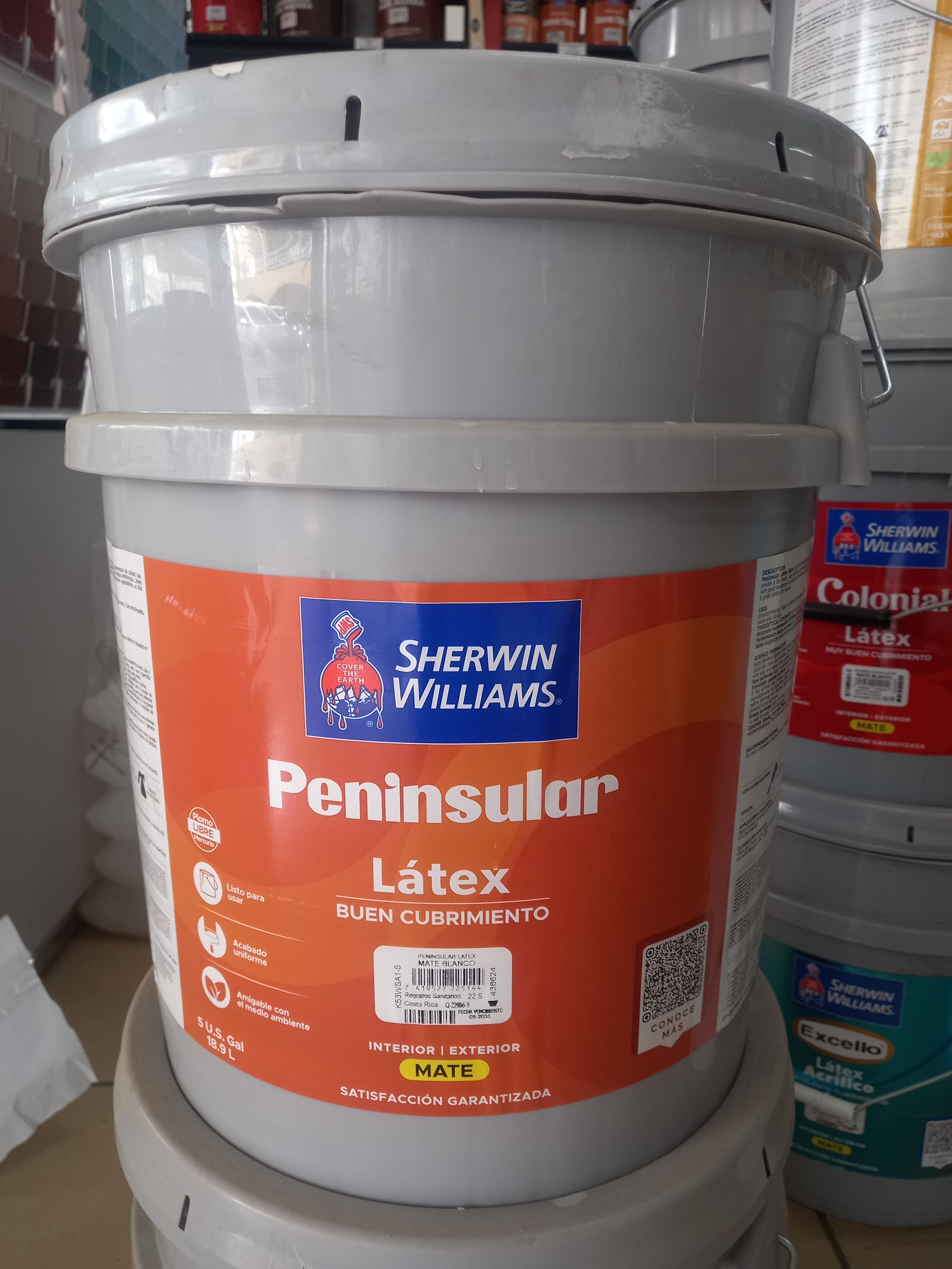 Vista frontal de una cubeta de pintura Peninsular Látex con etiqueta naranja oscuro