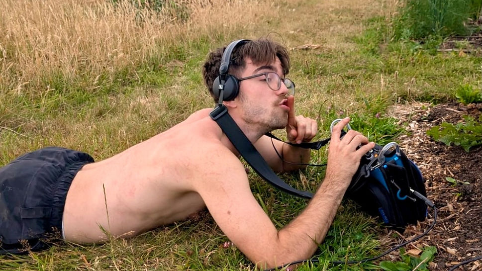 Generation Soil founder Alex Montgomery lying in the grass listening to the soil