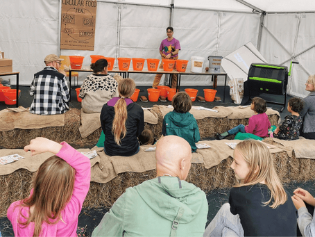 alex montgomery in front of crowd of people delivering food education workshop.